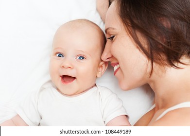 Cheerful Mother And Baby Lying In Bed