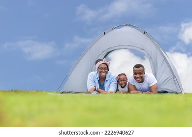 Cheerful mother father and daughter playing camping at outdoor, African American family enjoying in the park, Happiness family concepts - Powered by Shutterstock