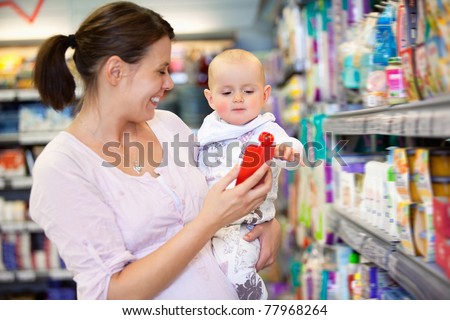 Cheerful mother playing with baby and spending time in shopping store