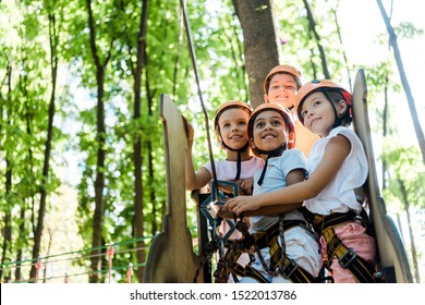 Cheerful Multicultural Kids Looking Up In Adventure Park Outside 