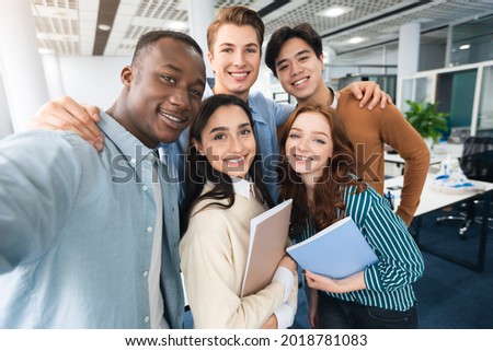 Cheerful Multicultural Students Posing Together Making Selfie In University Lecture Hall Indoors, Having Fun And Looking At Camera, Point Of View. College Friends, High School Education Concept