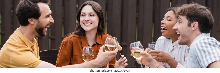 Cheerful Multiethnic Friends Holding Glasses With Wine During Party In Backyard, Banner