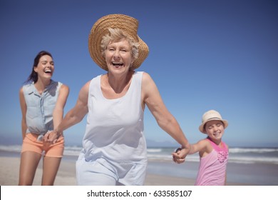 Cheerful multi-generation family at beach during sunny day - Powered by Shutterstock