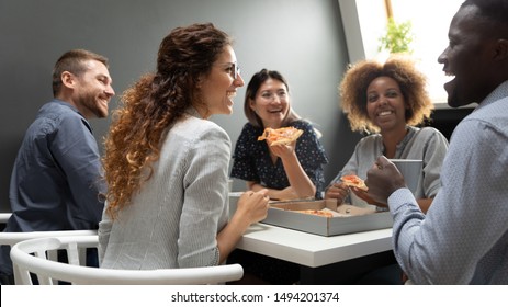 Cheerful Multiracial Business Team People Having Fun Eat Pizza Together, Happy Diverse Company Staff Workers Group Chatting Laughing In Office Share Lunch Food Meal Enjoy Party At Work Sit At Table