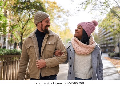 Cheerful multiracial couple walking outside talking and looking at each other with complicity and love. - Powered by Shutterstock