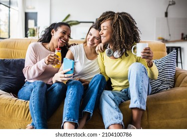 Cheerful multiracial female friends enjoying free time together at home - Three happy young adult women hanging out while - Friendship and social gathering concept - Shutterstock ID 2104100786