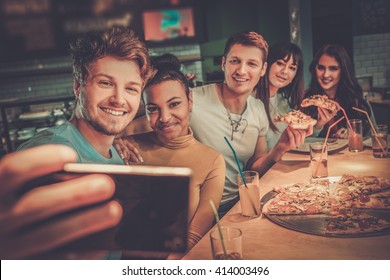 Cheerful Multiracial Friends Having Fun Eating In Pizzeria.