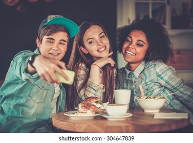 Cheerful Multiracial Friends Taking Selfie In A Cafe 