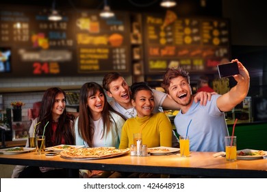 Cheerful Multiracial Friends Taking Selfie In Pizzeria.