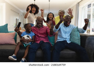 Cheerful multiracial multigeneration family screaming in joy while watching soccer match at home. Happy, unaltered, togetherness, love, childhood, lifestyle, retirement, enjoyment and winning. - Powered by Shutterstock