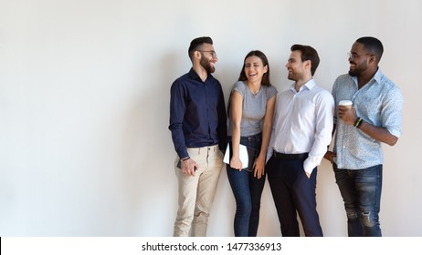 Cheerful multiracial professional business people laughing together standing in row near wall, happy diverse young employees students group, corporate staff team having fun, human resource concept - Shutterstock ID 1477336913