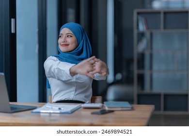 Cheerful muslim lady wear hijab working in the office, using laptop, Side view of smiling arab woman, freelancer typing on laptop, Muslim working woman concept. - Powered by Shutterstock