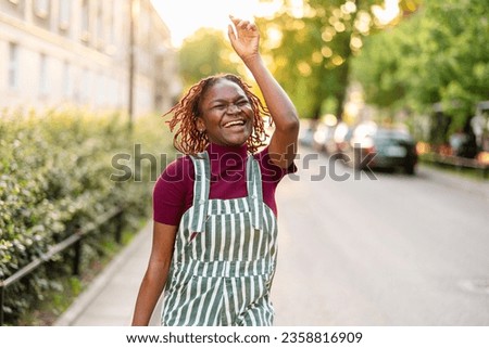 Similar – Image, Stock Photo Cheerful non-binary person dancing on the street in the city