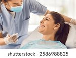 Cheerful nurse or doctor orthodontist conducting an oral checkup on a happy female patient using dental instruments in the clinic. Comprehensive dental care provided by the dentist.