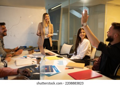 Cheerful Office People Group Talking And Enjoying Teamwork During Staff Meeting. Happy Coworkers Have Fun Working Together At Office. Teamwork Concept. Female Boss Presenting New Project.