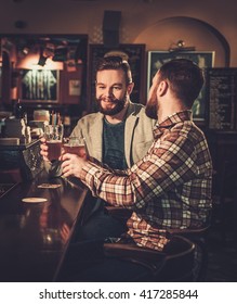 Cheerful Old Friends Drinking Draft Beer At Bar Counter In Pub.