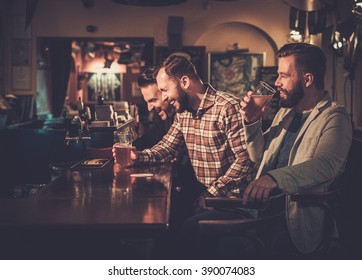 Cheerful Old Friends Having Fun And Drinking Draft Beer At Bar Counter In Pub.