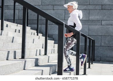 Cheerful Old Lady Training To Run Up Concrete Stairs