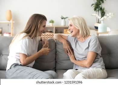 Cheerful Old Mother And Young Adult Woman Talking Laughing Together, Smiling Elderly Older Mum Having Fun Chatting With Grown Daughter, Two Age Generations Pleasant Conversation At Home Concept