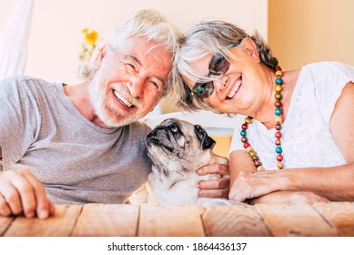 Cheerful Old Senior Couple Smile And Enjoy Her Best Friend Dog Pug With Love - Concept Of Happy Mature People And Animal - Joy Retired Elderly Lifestyle