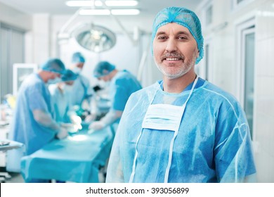 Cheerful old surgeon is examining the operation