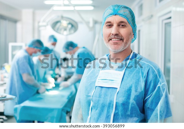 Cheerful old\
surgeon is examining the\
operation