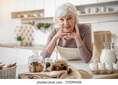 Cheerful Old Woman Cooking At Home