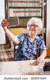 Cheerful Old Woman Taking Selfie Photo Using Smartphone At Home.