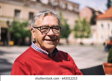 Cheerful Older Man Enjoys Sitting At The Bar In The City.Portrait Of Senior Man At The Cafe
Image Is Intentionally Toned.