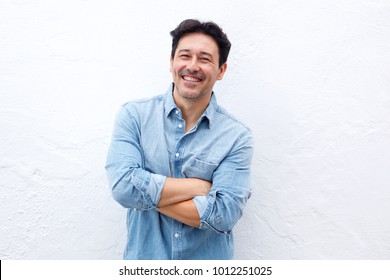 Cheerful Older Man Standing With Arms Crossed On White Background