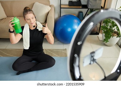 Cheerful Online Fitness Instructor Showing Her Favorite Protein Shake To Subscribers