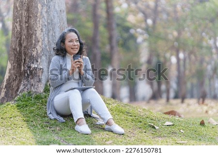 Cheerful overjoyed woman happy and enjoying peaceful beautiful in park and holding hot coffee