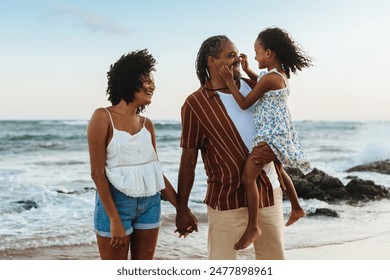 Cheerful parents enjoying a beach vacation with their daughter. Family bonding and joy on a sunny day by the sea. - Powered by Shutterstock