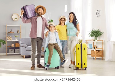 Cheerful parents, mother, father with two kids boy and girl with luggage going to vacation holiday trip standing in living room at home. Happy smiling family looking at camera ready to summer travel. - Powered by Shutterstock