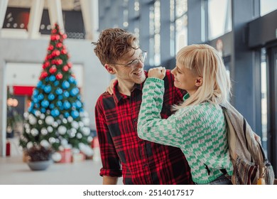 Cheerful passengers standing at metro station, hugging and smiling at each other. Young trendy affectionate couple is standing at metro station and embracing while smiling at each other. Copy space. - Powered by Shutterstock