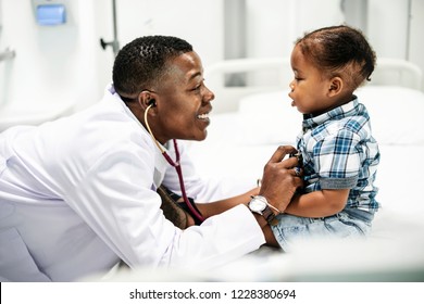 Cheerful pediatrician doing a medical checkup of a young boy - Shutterstock ID 1228380694