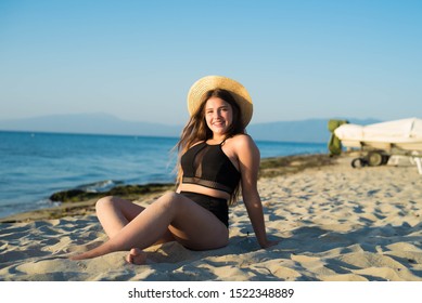 Cheerful Plus Size Teenage Girl Wearing Hat Enjoying The Beach. Smiling, Happy, Positive Emotion, Summer Style.