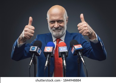 Cheerful politician celebrating his success and giving a speech to the media - Powered by Shutterstock