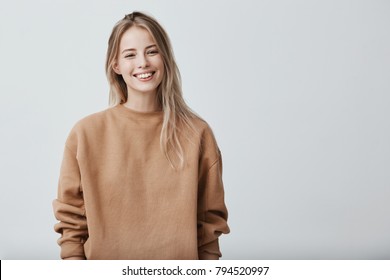 Cheerful positive female youngster with blonde hair, dressed casually, glad to receive graduation congratulations from friends, starting new stage in life. Positive emotions and feelings - Shutterstock ID 794520997