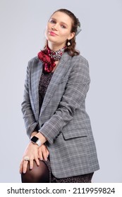 Cheerful Pregnant Woman In A Loose Dress And Jacket On Grey Background