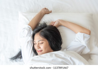 Cheerful pretty asian woman sleeping while lying in bed comfortably and blissfully. , Home lifestyle woman relaxing sleeping on bed in bedroom
