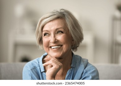 Cheerful pretty older woman with trendy hairstyle and white teeth touching chin, looking away, thinking on beauty care, elderly skincare, cosmetology. Close up facial portrait - Powered by Shutterstock