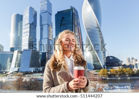 Cheerful pretty woman enjoying coffee and warm autumn sunny day