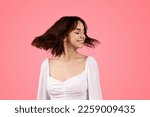 Cheerful pretty young european female turn head with closed eyes, enjoy freedom, lifestyle and holiday, isolated on pink background, studio. Fun alone, spare time, celebration huge sale, ad and offer