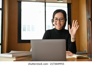 Cheerful And Professional Young Asian Female Online Tutor Or Teacher Teaching Her Students On Online Via Laptop Computer. E-learning Concept