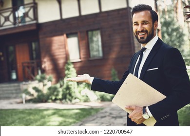 Cheerful professional young realtor looking happy and smiling while demonstrating the house - Shutterstock ID 1220700547