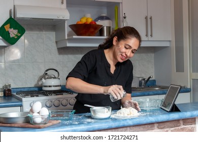 Cheerful real young woman preparing dough for an apple pie in the kitchen at home. Flour, eggs, butter apple - Powered by Shutterstock