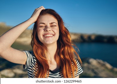 Cheerful red-haired woman on a summer holiday        - Shutterstock ID 1262299465