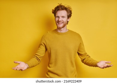 Cheerful Redhead Man Gesturing Welcome Sign While Standing Against Yellow Background