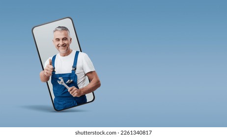 Cheerful repairman and plumber giving a thumbs up in a smartphone videocall and smiling, online  service concept - Powered by Shutterstock